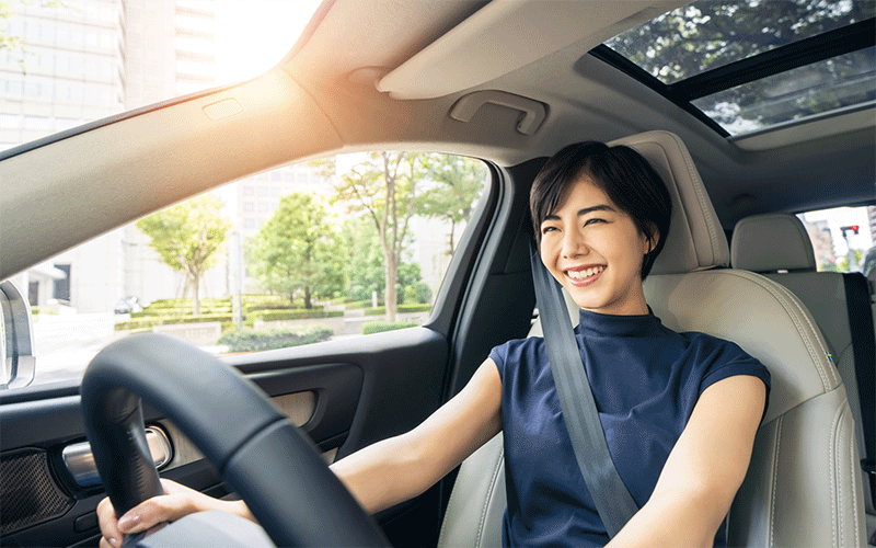 笑顔で車を運転する女性